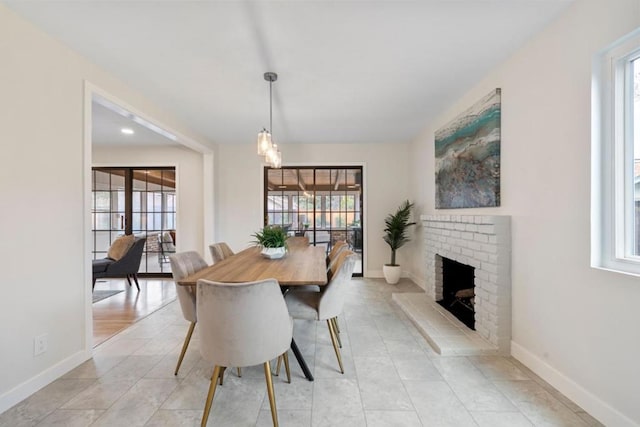 dining room featuring light tile patterned floors and a fireplace