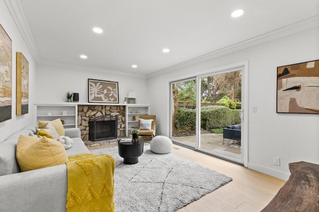 living room with ornamental molding, a stone fireplace, and light hardwood / wood-style floors