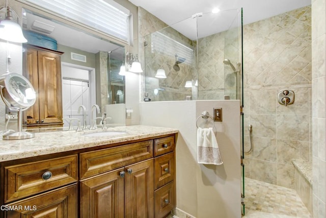 bathroom featuring vanity and tiled shower