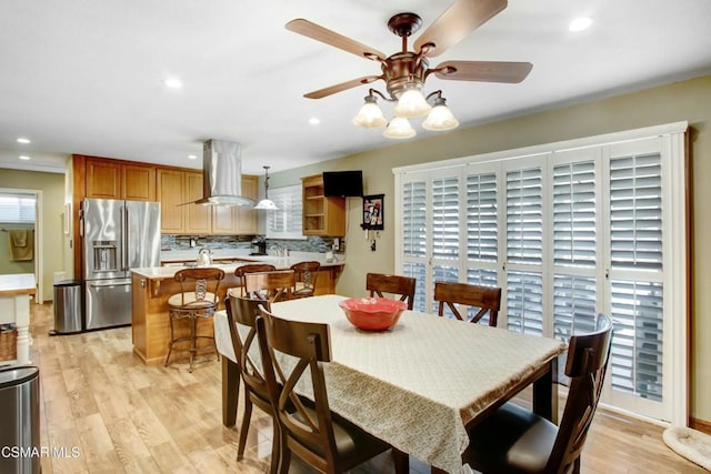 dining room with a wealth of natural light, light hardwood / wood-style floors, and ceiling fan