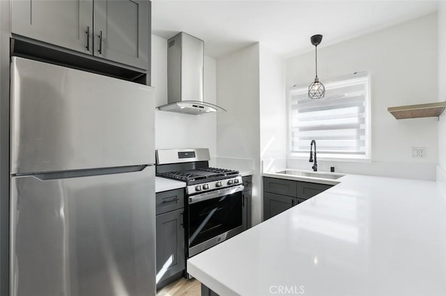 kitchen with wall chimney range hood, gray cabinets, stainless steel appliances, and sink