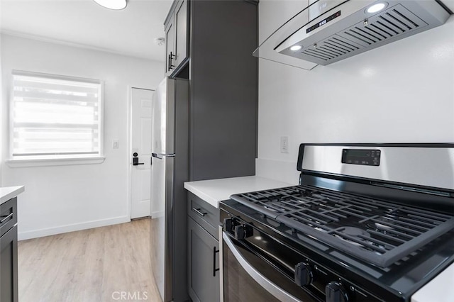 kitchen with gas stove, wall chimney range hood, and light hardwood / wood-style floors