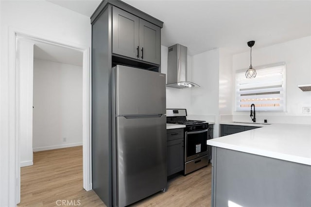 kitchen featuring stainless steel appliances, sink, gray cabinets, and wall chimney exhaust hood