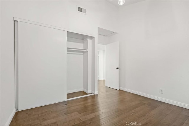 unfurnished bedroom featuring dark hardwood / wood-style floors and a closet