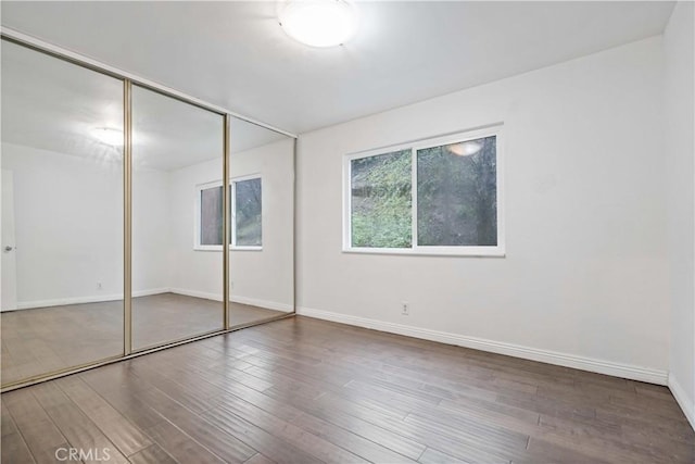 unfurnished bedroom with hardwood / wood-style flooring and a closet