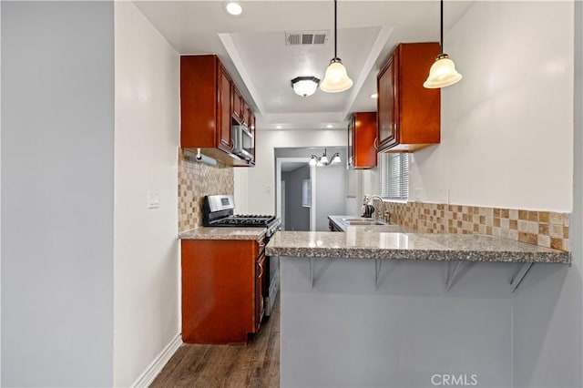 kitchen featuring pendant lighting, a breakfast bar area, kitchen peninsula, and appliances with stainless steel finishes