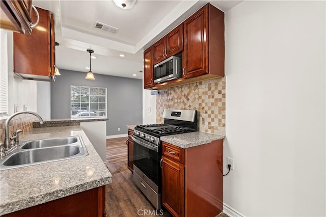 kitchen with pendant lighting, sink, backsplash, stainless steel appliances, and dark wood-type flooring