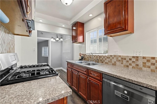 kitchen featuring stainless steel gas range, sink, hanging light fixtures, dishwasher, and backsplash