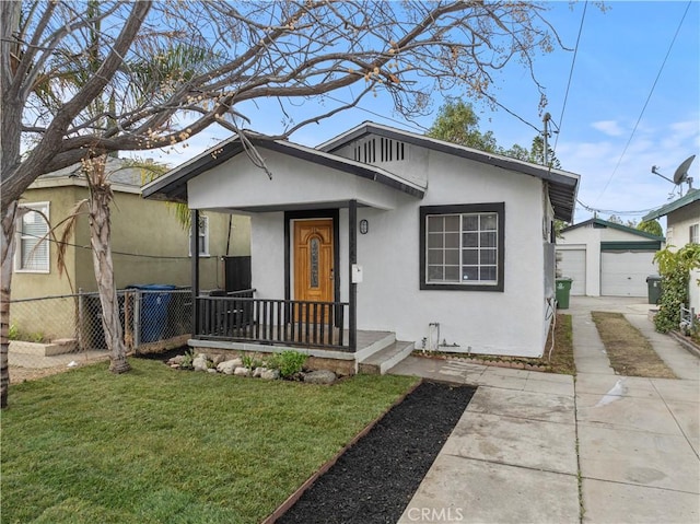 bungalow-style home with an outbuilding, a garage, a front lawn, and covered porch