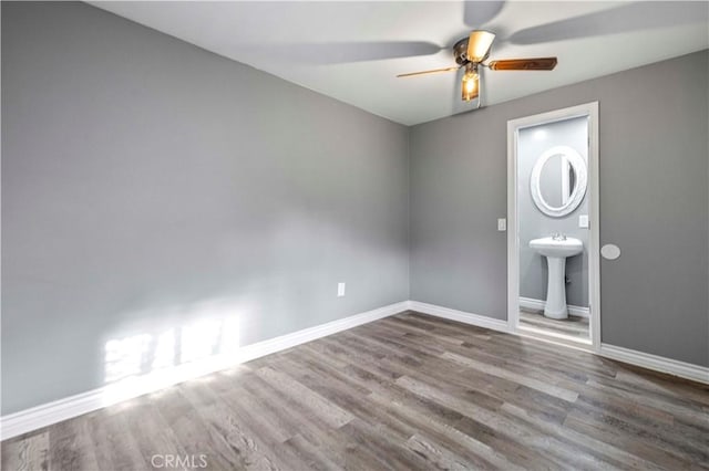 spare room with wood-type flooring, sink, and ceiling fan