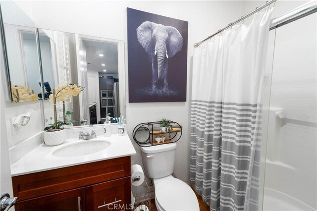 bathroom featuring vanity, toilet, and a shower with shower curtain