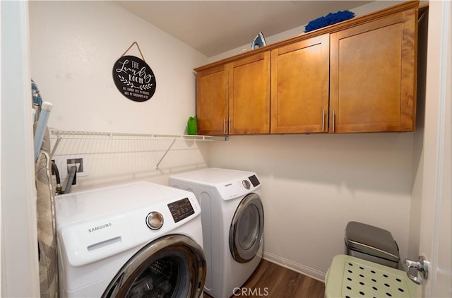 laundry room with dark hardwood / wood-style floors, cabinets, and washing machine and clothes dryer