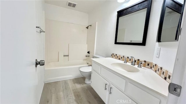 full bathroom featuring vanity, toilet, tub / shower combination, and hardwood / wood-style floors