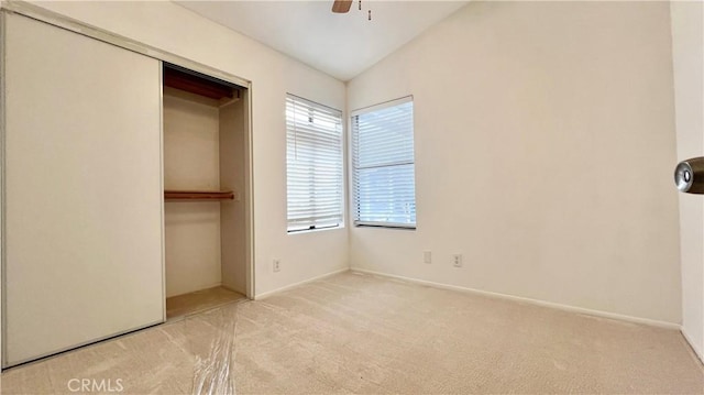 unfurnished bedroom with lofted ceiling, light colored carpet, ceiling fan, and a closet