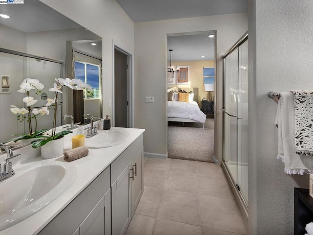 bathroom featuring tile patterned flooring, vanity, and a shower with door