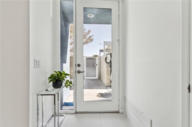 doorway to outside with light tile patterned floors and visible vents