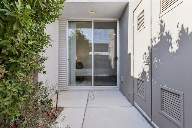 doorway to property featuring a patio area and stucco siding