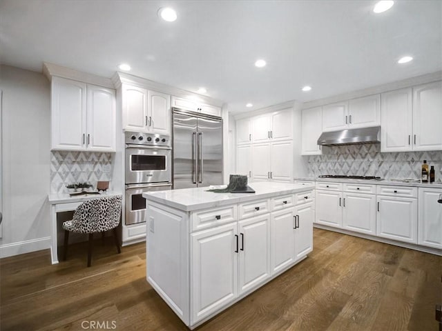 kitchen featuring stainless steel appliances, a center island, white cabinets, and dark hardwood / wood-style floors