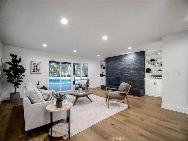 living room with built in shelves and hardwood / wood-style floors