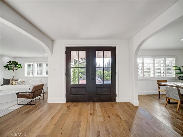 entrance foyer with french doors and light hardwood / wood-style floors