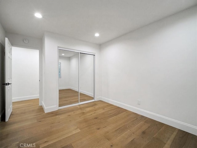 unfurnished bedroom featuring hardwood / wood-style floors and a closet