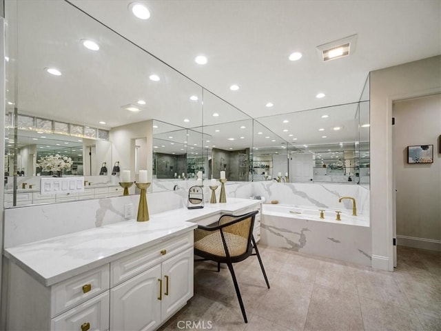 bathroom with vanity, a relaxing tiled tub, and tile patterned floors