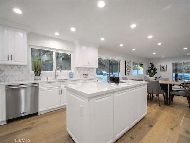 kitchen with dishwasher, sink, and white cabinets