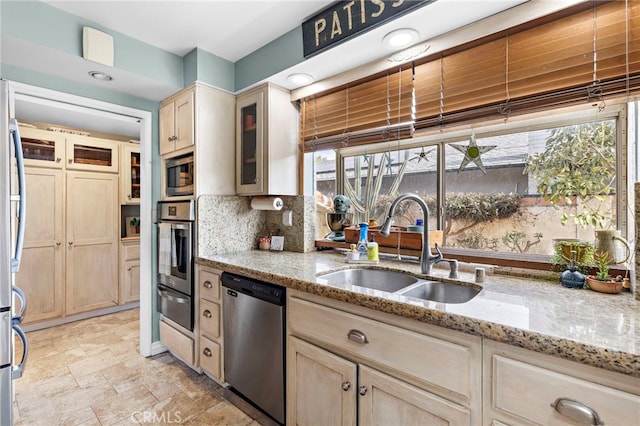 kitchen with sink, light brown cabinets, light stone countertops, and appliances with stainless steel finishes