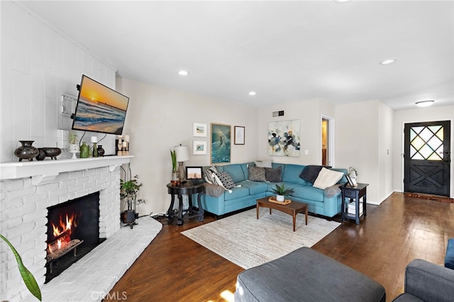 living room featuring dark wood-type flooring and a fireplace