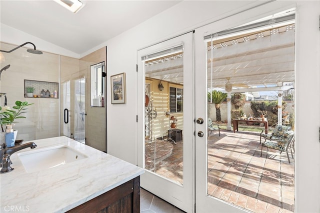 bathroom with vanity, an enclosed shower, lofted ceiling, and french doors