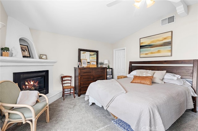 carpeted bedroom featuring ceiling fan, a fireplace, and lofted ceiling with beams