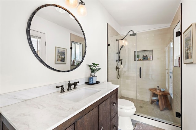 bathroom featuring vanity, toilet, and a shower with shower door