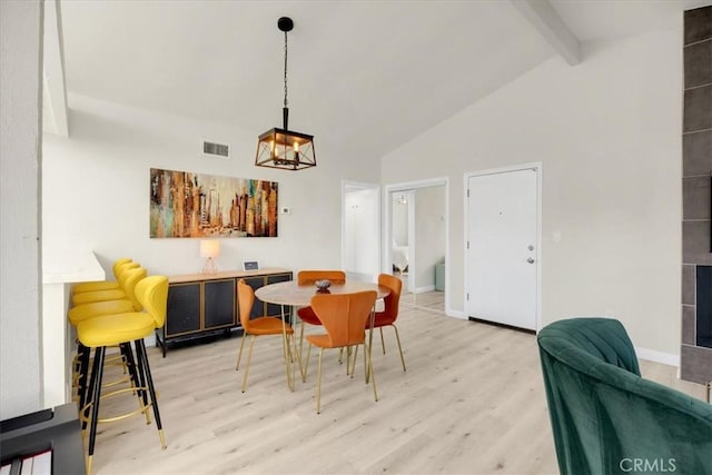 dining room with high vaulted ceiling, hardwood / wood-style floors, and beam ceiling