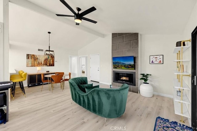 living room featuring ceiling fan, a fireplace, lofted ceiling with beams, and wood-type flooring