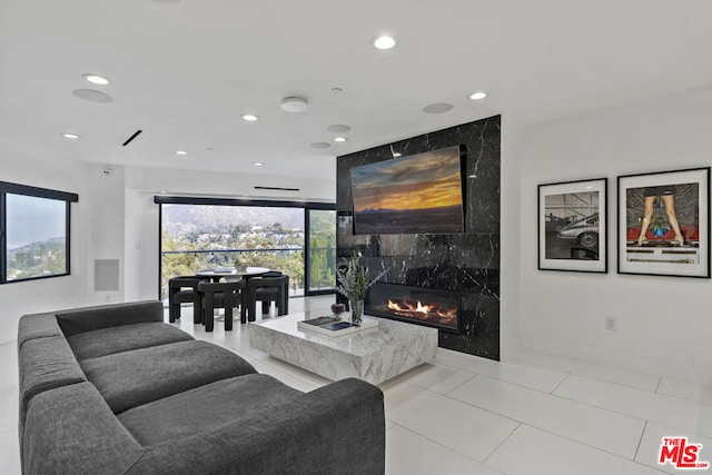 living room featuring a premium fireplace and light tile patterned floors