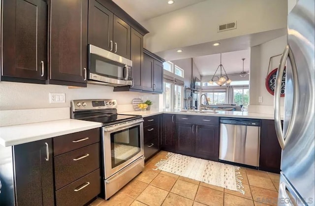 kitchen featuring dark brown cabinetry, sink, kitchen peninsula, and appliances with stainless steel finishes