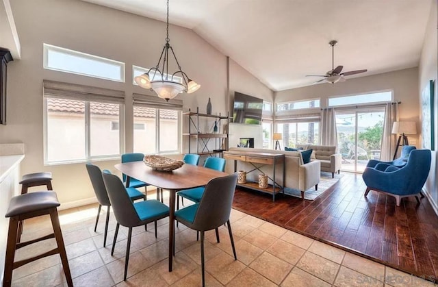 dining area featuring ceiling fan, high vaulted ceiling, and light tile patterned floors