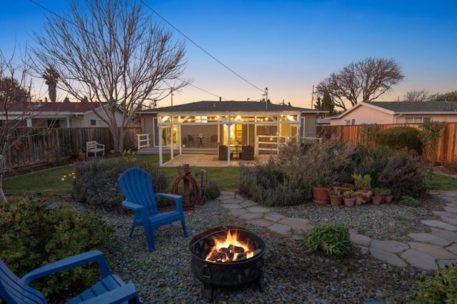 back house at dusk with a patio and an outdoor fire pit