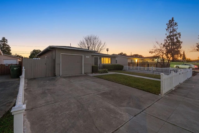 ranch-style house with a garage and a yard