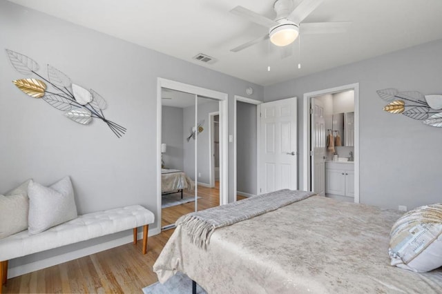 bedroom featuring ceiling fan, ensuite bath, a closet, and light wood-type flooring