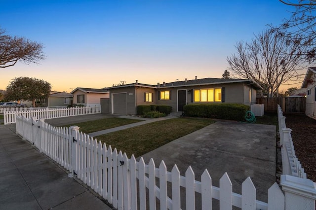 ranch-style home with a garage and a yard