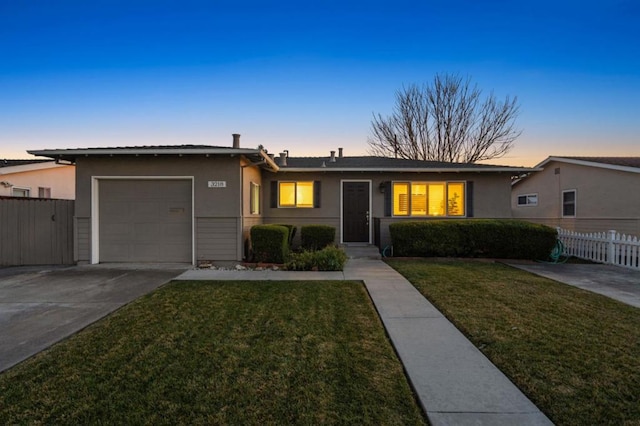 ranch-style home with a yard and a garage