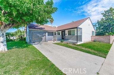 single story home with a garage and a front lawn