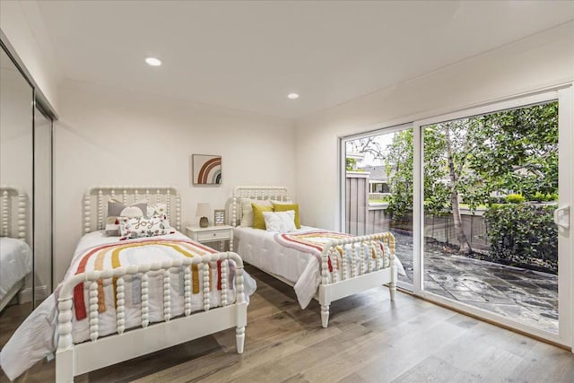 bedroom with access to exterior and light wood-type flooring