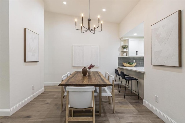 dining room with hardwood / wood-style flooring and a chandelier