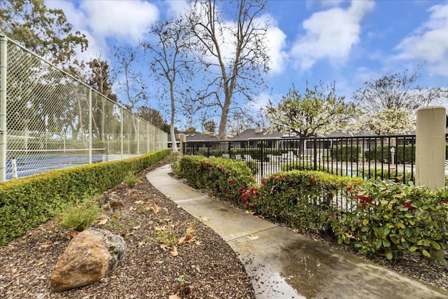 view of property's community featuring tennis court