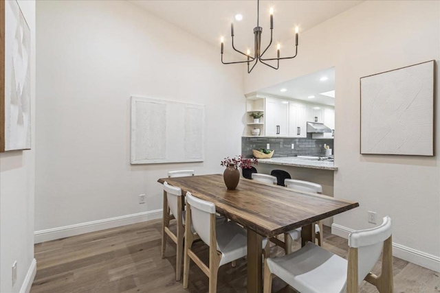 dining space with hardwood / wood-style flooring and a chandelier