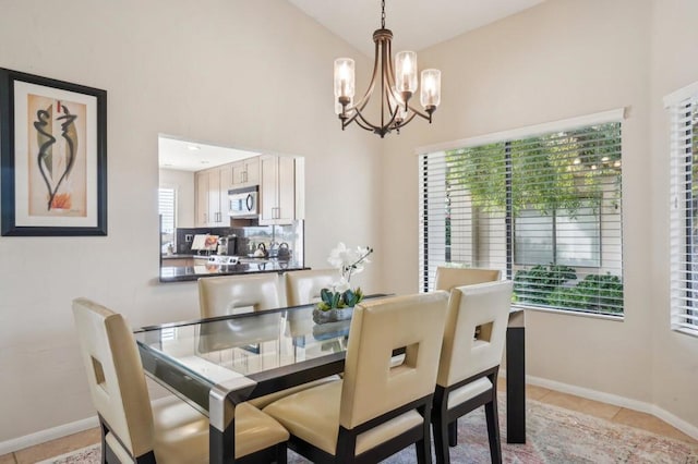 dining space with light tile patterned floors and a chandelier