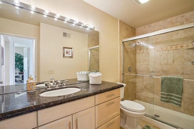 bathroom with vanity, an enclosed shower, and toilet