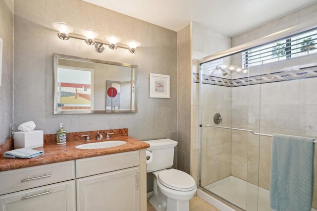 bathroom featuring vanity, a shower with shower door, and toilet